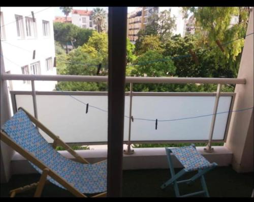 un par de sillas sentadas en un balcón con ventana en En plein coeur de Nice en Niza