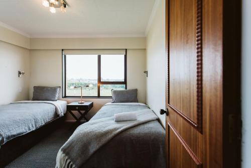 新普利茅斯的住宿－ABC On Wanaka Bay Support Local，小房间设有两张床和窗户