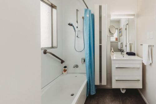 a white bathroom with a shower and a sink at Love It On Lemon in New Plymouth