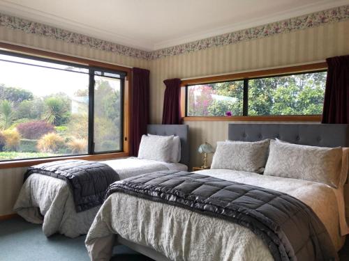 a bedroom with two beds and a large window at Mt Taranaki Vista 