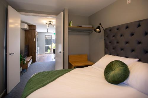 a bedroom with a large bed with a green pillow on it at The Residence Apartment 9 50 Sky in New Plymouth