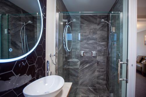 a bathroom with a sink and a shower at The Residence Apartment 9 50 Sky in New Plymouth