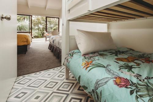 a bedroom with a bed and a bunk bed at The Beach Retreat Sleeps 12 in Oakura