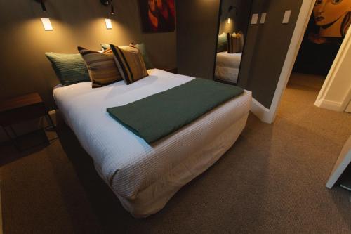 ein Schlafzimmer mit einem großen Bett mit weißer Bettwäsche und Kissen in der Unterkunft Stay Central The Loft in New Plymouth