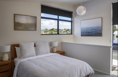 a bedroom with a bed and a large window at Mountain View Ark Apartment in New Plymouth