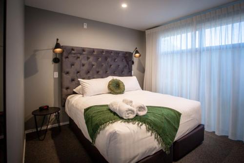een slaapkamer met een bed met twee knuffels erop bij The Residence Apartment Five with Spa Bath in New Plymouth