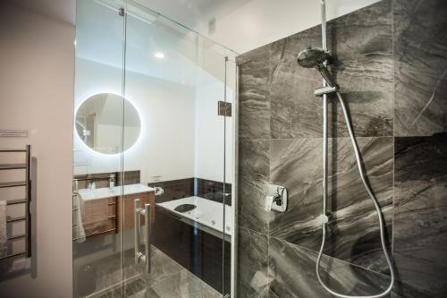 een badkamer met een douche en een wastafel bij The Residence Apartment Five with Spa Bath in New Plymouth