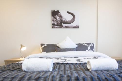 a bedroom with a bed with an elephant picture on the wall at The Strandon Loft No 7 Prime Location in New Plymouth