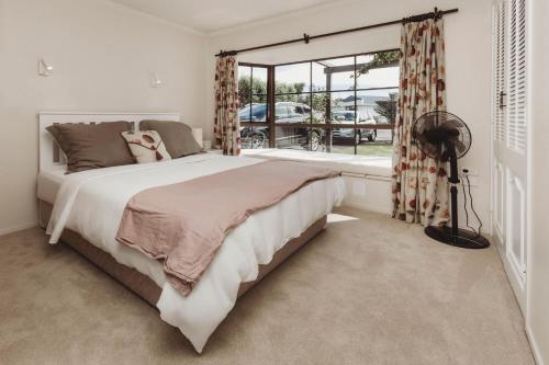 新普利茅斯的住宿－Family Fun Swimming Pool Spa Pool，一间卧室设有一张大床和一个窗户。
