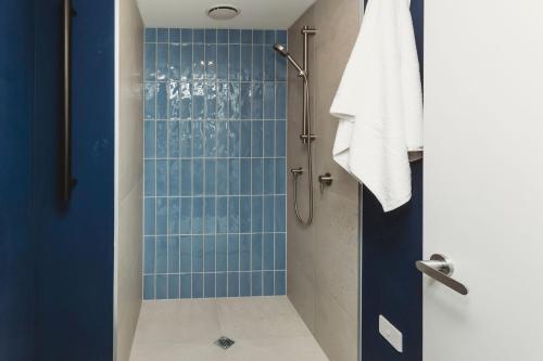 a bathroom with a shower with blue tile at One50 Molesworth L1 - Sleeps 6 in New Plymouth