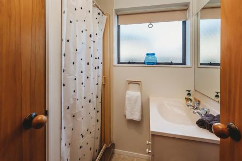 a bathroom with a sink and a rock wall at The Gilbert Getaway in New Plymouth