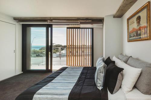 a bedroom with a bed and a view of the ocean at One50 Molesworth L1 - Sleeps 6 in New Plymouth