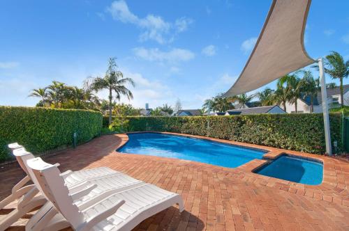 a pair of chairs and a swimming pool with a pair at Quarterdeck 8 in Lennox Head