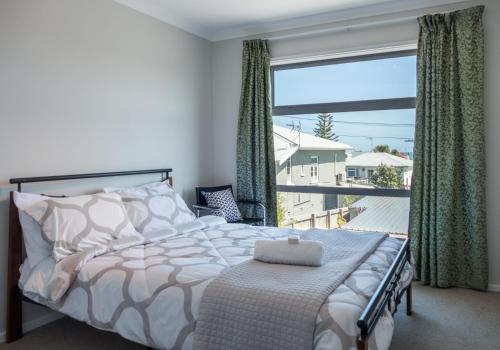 a bedroom with a bed and a large window at Magic On Molesworth Wow Factor Prime Location in New Plymouth