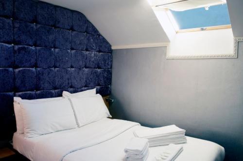 a bedroom with a bed with a blue headboard at The Cozy Corner Inn in Newport