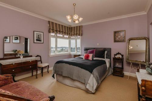 a bedroom with a bed and a dresser and a mirror at The lookout Central in New Plymouth