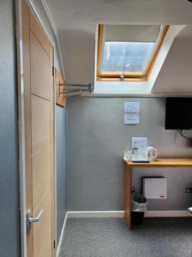 a room with a desk and a window and a door at The Cozy Corner Inn in Newport