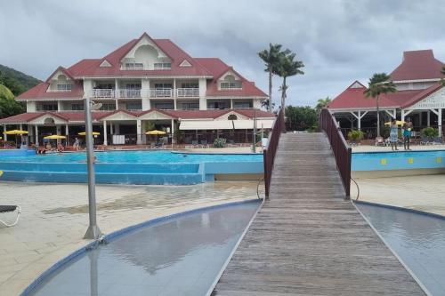 un paseo marítimo que conduce a un complejo con piscina en App Premium Tobago - Domaine P&V en Sainte-Luce