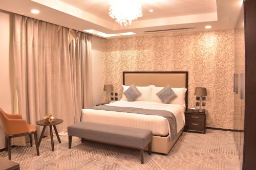 a bedroom with a large bed and a chandelier at Cloud City Hotel فندق مدينة السحاب in Al Baha