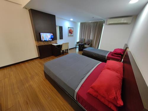 a hotel room with a bed and a television at Wan's Studio (Kota Bharu City Point) in Kota Bharu