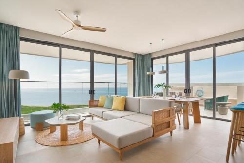 a living room with a couch and a table at IXORA Ho Tram By Fusion in Ho Tram