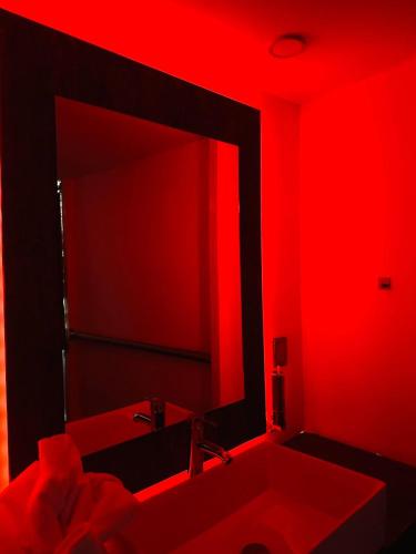 Baño rojo con lavabo y espejo en Ya no tenemos servicio, en Ciudad de México