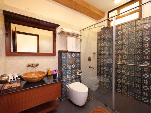 un bagno con lavandino, WC e doccia di Tapovana The Fern Heritage Resort, Sakleshpur a Sakleshpur