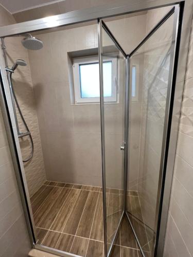 La salle de bains est pourvue d'une douche avec une porte en verre. dans l'établissement Varna downtown apartment, à Varna