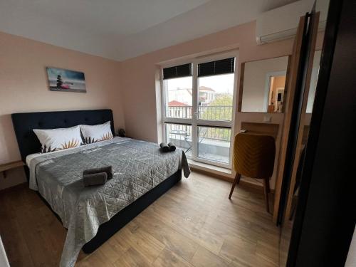 - une chambre avec un lit et une grande fenêtre dans l'établissement Varna downtown apartment, à Varna