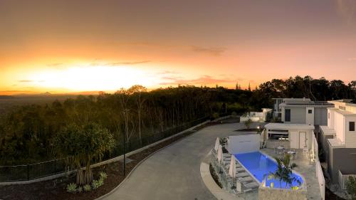 a view of a house with the sunset in the background at Essence Peregian Beach Resort - Saltbush 5 Bedroom Luxury Home in Peregian Beach