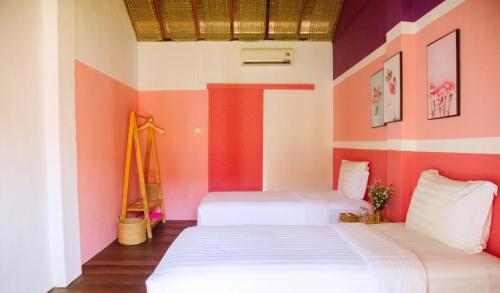 2 camas en una habitación con paredes rosas y blancas en Lumiere Family Village Dong Tac, en Hiếu Xương