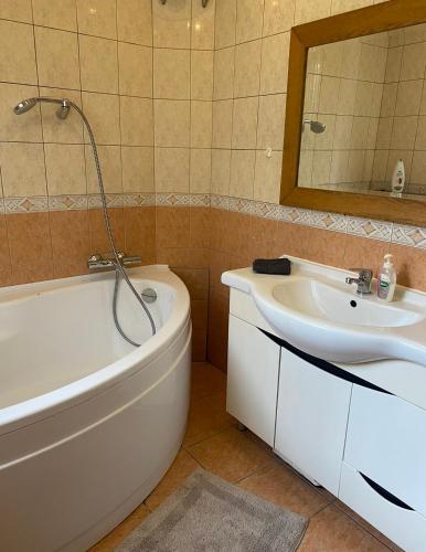 a bathroom with a bath tub and a sink at 2 bedroom apartment close to Kaunas airport in Karmelava in Karmėlava