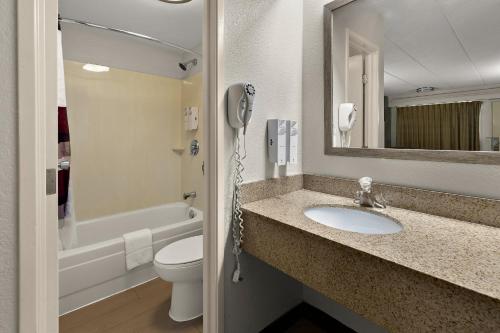 a bathroom with a sink and a toilet and a phone at Red Roof Inn Cleveland - Westlake in Westlake