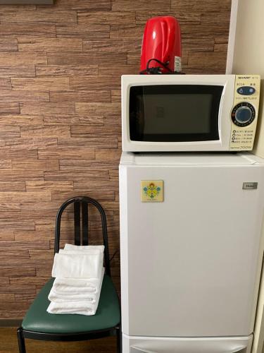 a microwave sitting on top of a refrigerator at La Foret Fujimi in Hiroshima