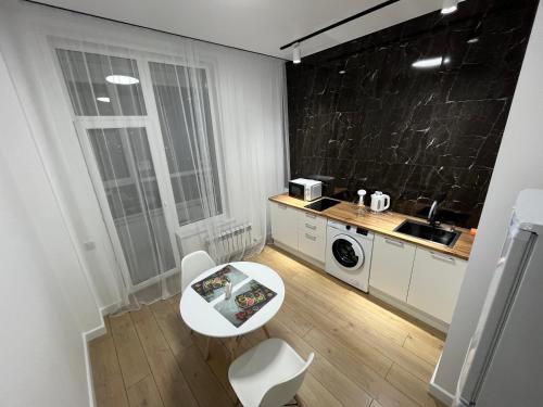 アスタナにあるRAISSON APARTHOTEL Sat CITY 145のテーブルとシンクのある小さなキッチン