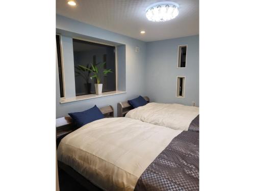 dwa łóżka w pokoju z oknem w obiekcie Seaside Garage Shima - Vacation STAY 85765v w mieście Shima
