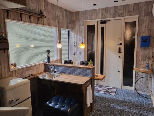 kuchnia z drewnianymi ścianami, umywalką i oknem w obiekcie Seaside Garage Shima - Vacation STAY 85765v w mieście Shima