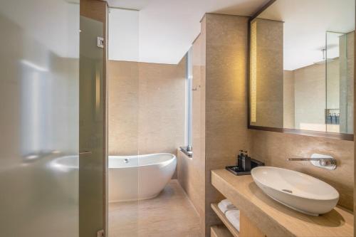 a bathroom with a white sink and a bath tub at Alila Solo in Solo