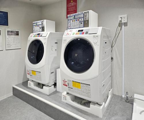 deux lave-linge sont exposés dans une pièce dans l'établissement Premier Hotel Cabin Shinjuku, à Tokyo