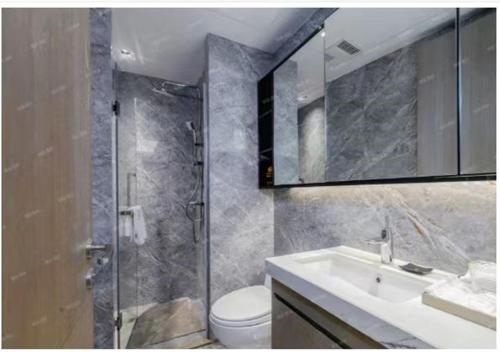 a bathroom with a shower and a sink and a toilet at Royal Executive Apartment, Shenzhen World Exhibition & Convention Center, Nearby Shenzhen World North Metro St ation in Bao'an