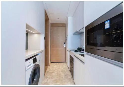 a kitchen with a washing machine and a washer and dryer at Royal Executive Apartment, Shenzhen World Exhibition & Convention Center, Nearby Shenzhen World North Metro St ation in Bao'an