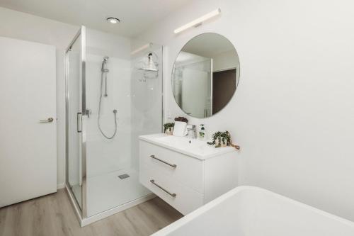 a white bathroom with a sink and a mirror at Bell Block Beauty Brand New in New Plymouth