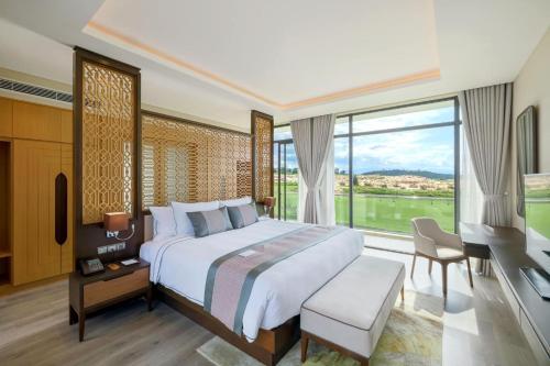 a bedroom with a large bed and a large window at Residence Inn Villa Cam Ranh in Cam Ranh