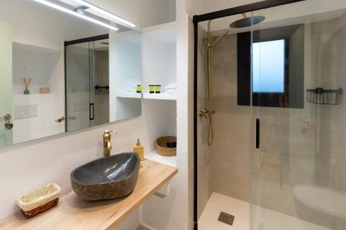 y baño con lavabo negro y ducha. en Empordanna, Apartamento con encanto en el corazón del Empordà en Torroella de Montgrí