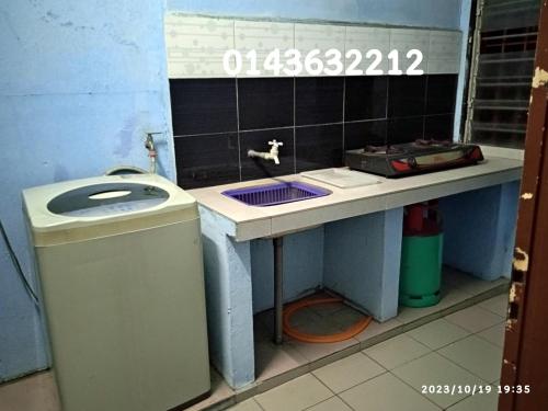 a bathroom with a sink and a trash can at Ekaira homestay in Tambun