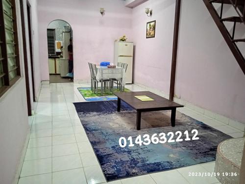 una sala de estar con una mesa sobre una alfombra en Ekaira homestay en Tambun