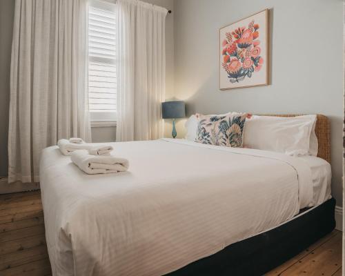 Un dormitorio con una cama blanca con toallas. en La Mia Casa 159 - The Entertainer, en Orange