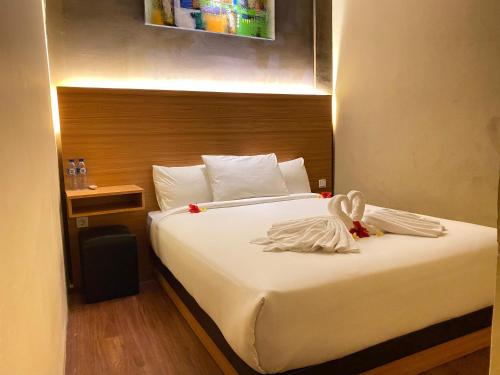 um quarto de hotel com uma cama com uma toalha em Asiana Lovina Hotel em Lovina