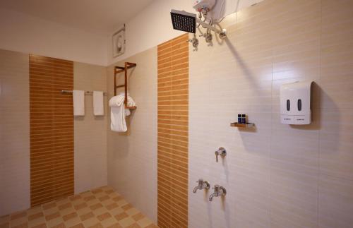 a bathroom with a shower with orange and white tiles at Seclude Kerala, Beach House in Mararikulam