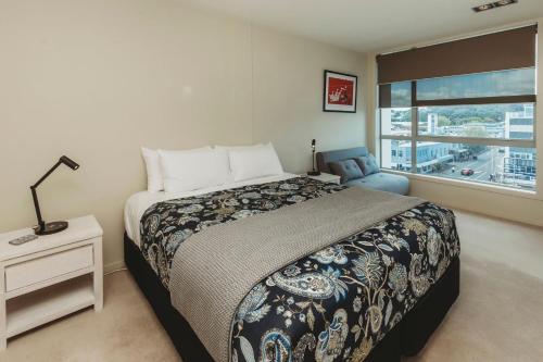 a bedroom with a large bed and a window at Liardet22 The Penthouse in New Plymouth